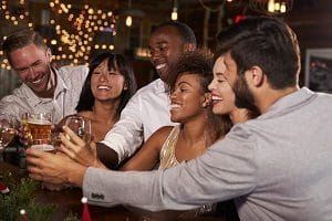 Friends at a Christmas party making a toast at the bar